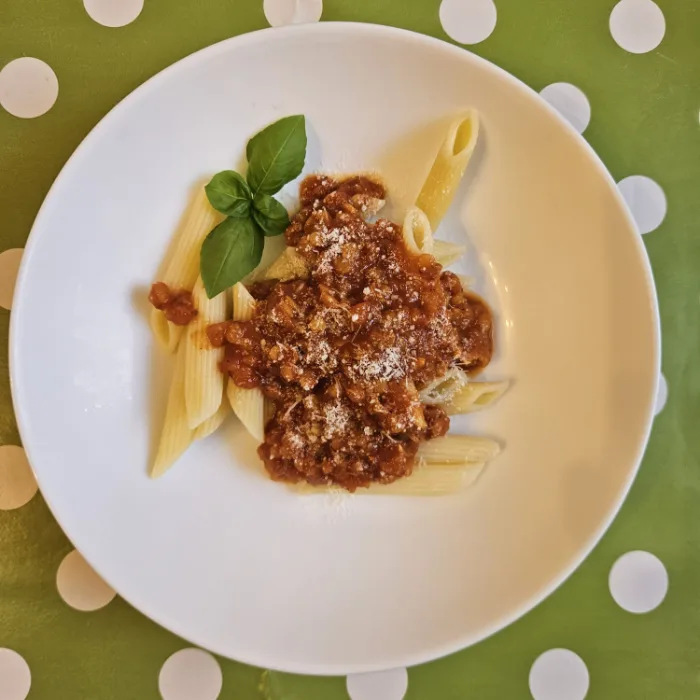 Teller mit Penne und Bolognese
